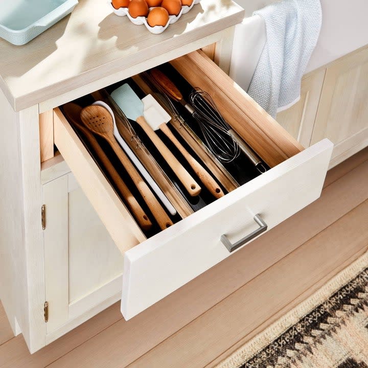 The organizer in a drawer with utensils in it