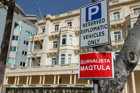 A placard reading: "A journalist murdered" is seen outside Whitehall Mansions, which houses the Maltese-registered Pilatus Bank in Ta' Xbiex, Malta March 21, 2018. REUTERS/Darrin Zammit Lupi