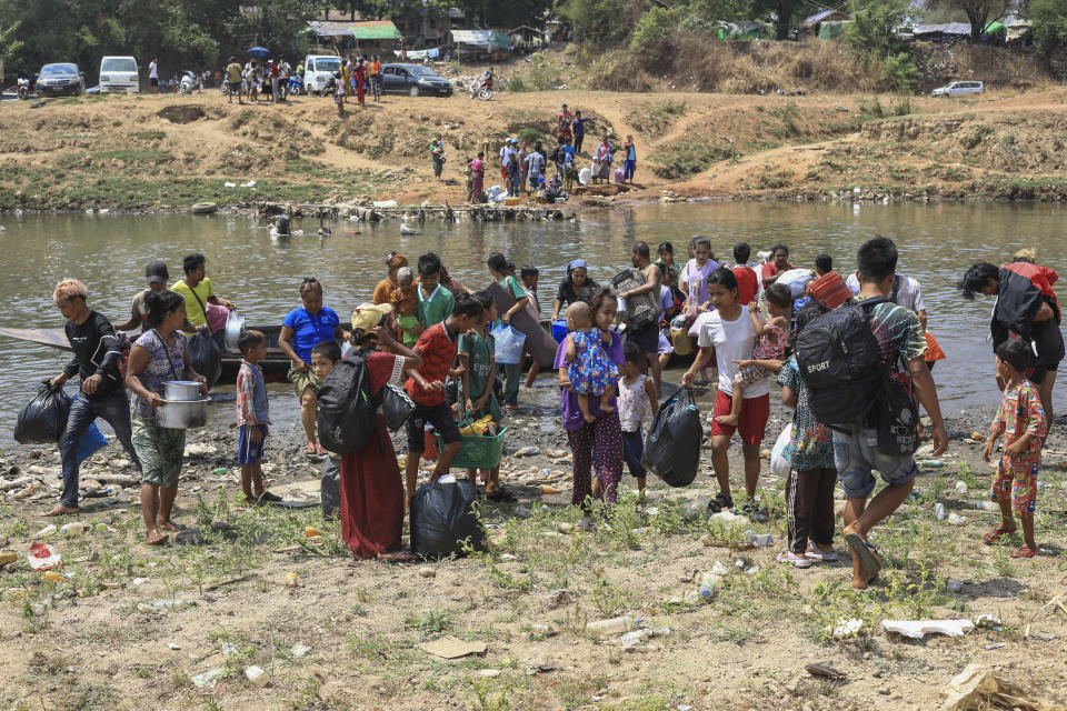 People cross the Moei river as they flee Myawaddy township in Myanmar to Thailand's Mae Sot town in Thailand's Tak province, Saturday, April 20, 2024. About 1,300 people have fled from eastern Myanmar into Thailand, officials said Saturday, as fresh fighting erupted near a border town that has recently been captured by ethnic guerillas. (AP Photo/Warangkana Wanichachewa)