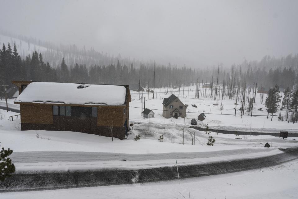 Snow falls on homes on Sierra Pines Road in El Dorado County, Calif. on Thursday, Feb. 29, 2024, as a blizzard is expected to add to snow in the area. The most powerful Pacific storm of the season started barreling into the Sierra Nevada on Thursday, packing multiple feet of snow and dangerous winds that forecasters say will create blizzard conditions likely to close major highways and trigger power outages into the weekend. (Hector Amezcua/The Sacramento Bee via AP)