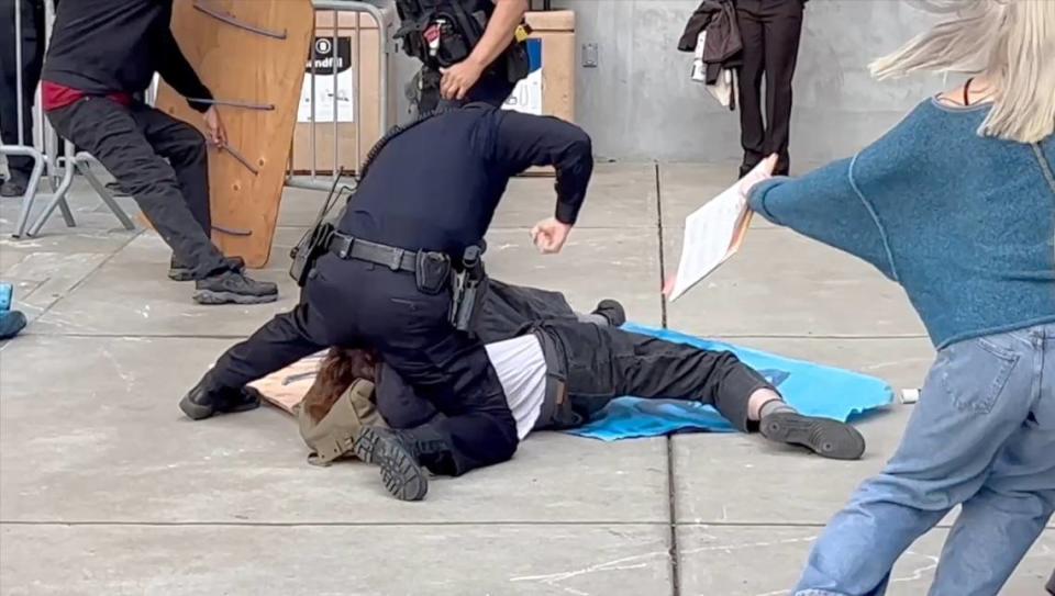 A San Luis Obispo police officer strikes a protester at Cal Poly on Tuesday, Jan. 23, 2024, after a demonstration turned violent when the university said activists tried to force their way into a career fair at the Rec Center.