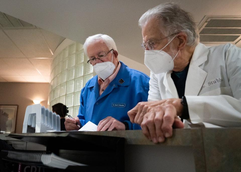 Dr. Kent Macauley and Dr. Paul Stubbs go over paperwork for Season for Caring recipients. The dentists, members of the Capital Area Dental Foundation, donated care Nov. 19.