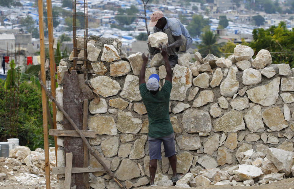 Haitians construct a wall as they rebuild a destroyed house on Jan. 7, 2011.