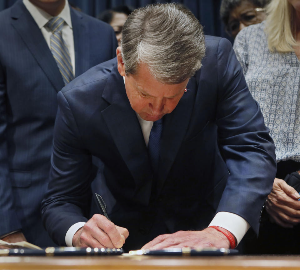 File-This May 7, 2019, file photo shows Georgia's Republican Gov. Brian Kemp signing legislation, in Atlanta, banning abortions once a fetal heartbeat can be detected. A federal judge on Tuesday, Oct. 1, 2019, temporarily blocked Georgia’s restrictive new abortion law from taking effect, following the lead of other judges who have blocked similar measures in other states. The law signed in May by Republican Gov. Brian Kemp bans abortions once a fetal heartbeat is detected, which can happen as early as six weeks into a pregnancy, before many women realize they’re expecting. It allows for limited exceptions. (Bob Andres/Atlanta Journal-Constitution via AP, File)