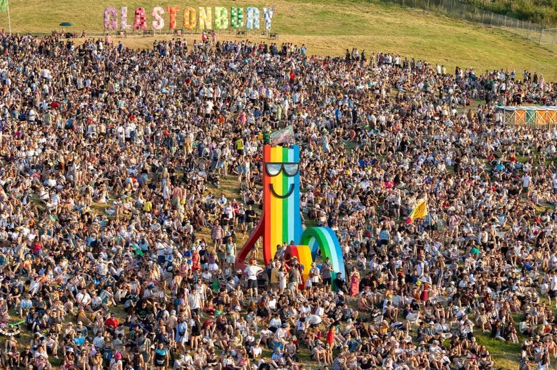 GLASTONBURY, ENGLAND - JUNE 26: People gather around the rainbow sculpture which overlooks the festival site during day one of Glastonbury Festival 2024 at Worthy Farm, Pilton on June 26, 2024 in Glastonbury, England. Founded by Michael Eavis in 1970, Glastonbury Festival features around 3,000 performances across over 80 stages. Renowned for its vibrant atmosphere and iconic Pyramid Stage, the festival offers a diverse lineup of music and arts, embodying a spirit of community, creativity, and environmental consciousness.(Photo by Matt Cardy/Getty Images)