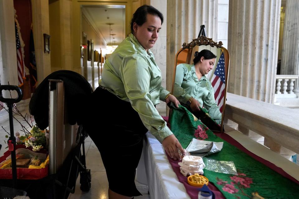 Maryam Attarpour packs up cookies and flowers from a display table set up outside the State Room on Thursday afternoon in a first for the the RI State House, an honoring of the Persian New Year coming on Monday.