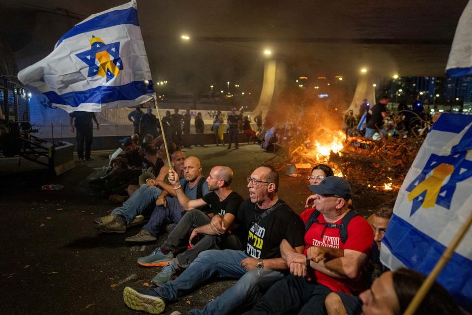 People block a road as they protest, calling for a deal for the immediate release of hostages held in the Gaza Strip by Hamas, in Tel Aviv, Israel, Sunday, Sept. 1, 2024.