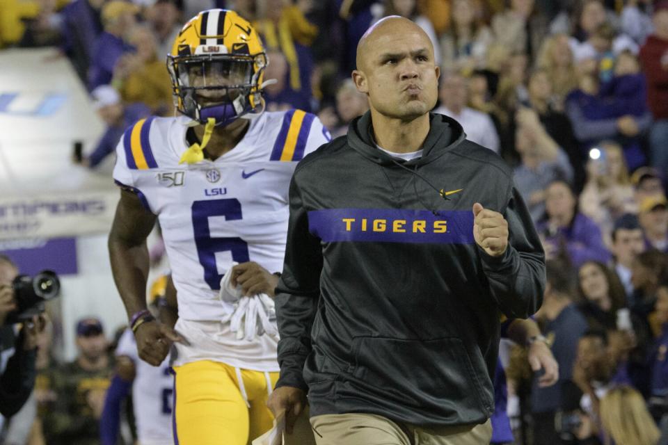 LSU defensive coordinator Dave Aranda runs on the field against Arkansas