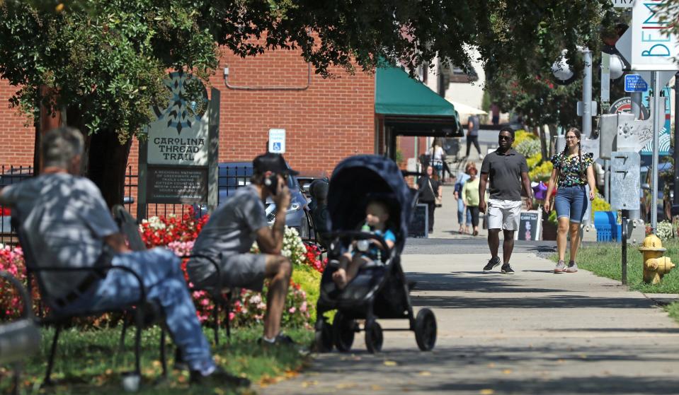 People walk along main street in Belmont Friday afternoon, Sept. 15, 2023.