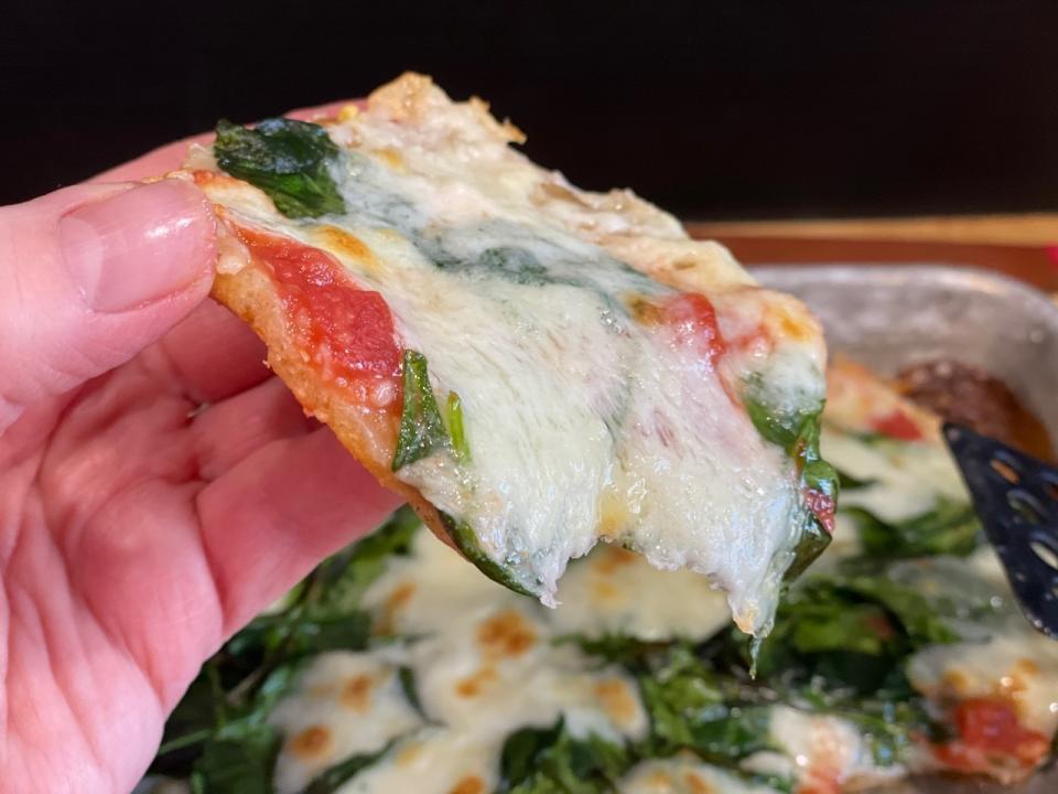 This Jan. 7, 2021 photo shows a slice of sheet-pan pizza, a fun meal to make with kids. (Elizabeth Karmel via AP)