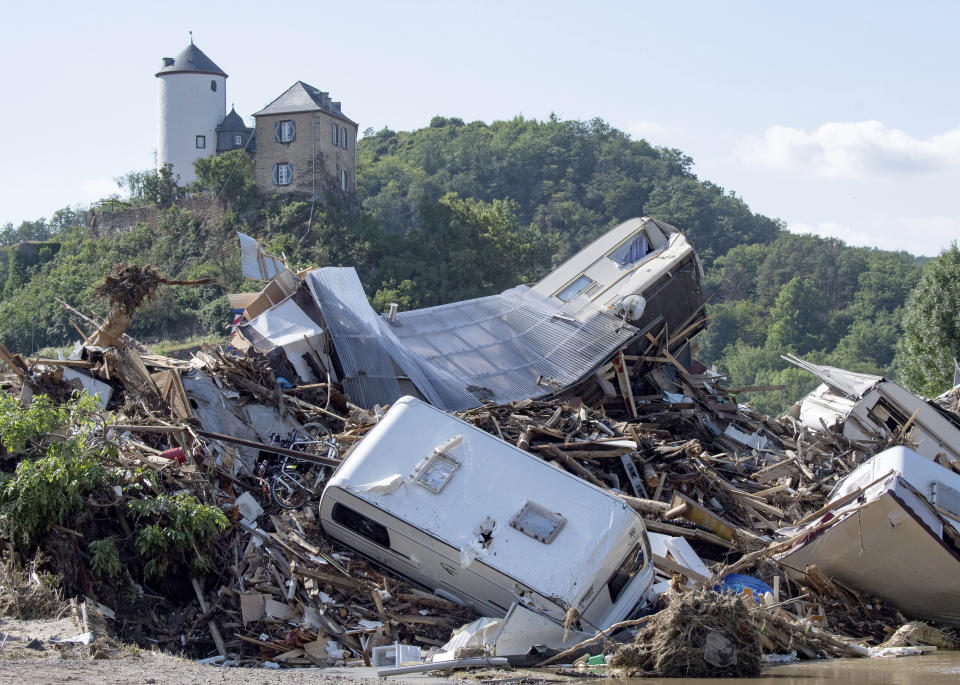 Dozens of caravans, cars and mobile homes that were swept away by the flood wave hang squeezed together on a bridge over the River Ahr, in Altenahr, western Germany, Sunday, July 18, 2021. Heavy rains caused mudslides and flooding in the western part of Germany. Multiple have died and are missing as severe flooding in Germany and Belgium turned streams and streets into raging, debris-filled torrents that swept away cars and toppled houses. (Boris Roessler/dpa via AP)