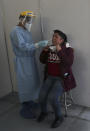 A doctor takes a sample for a COVID-19 test from a woman at the Mexico City Ajusco Medio General Hospital, Wednesday, Dec. 2. 2020. Mexico continues to report an increase in the number of coronavirus cases, with Mexico City continuing to report the biggest portion of the surge. (AP Photo/Marco Ugarte)