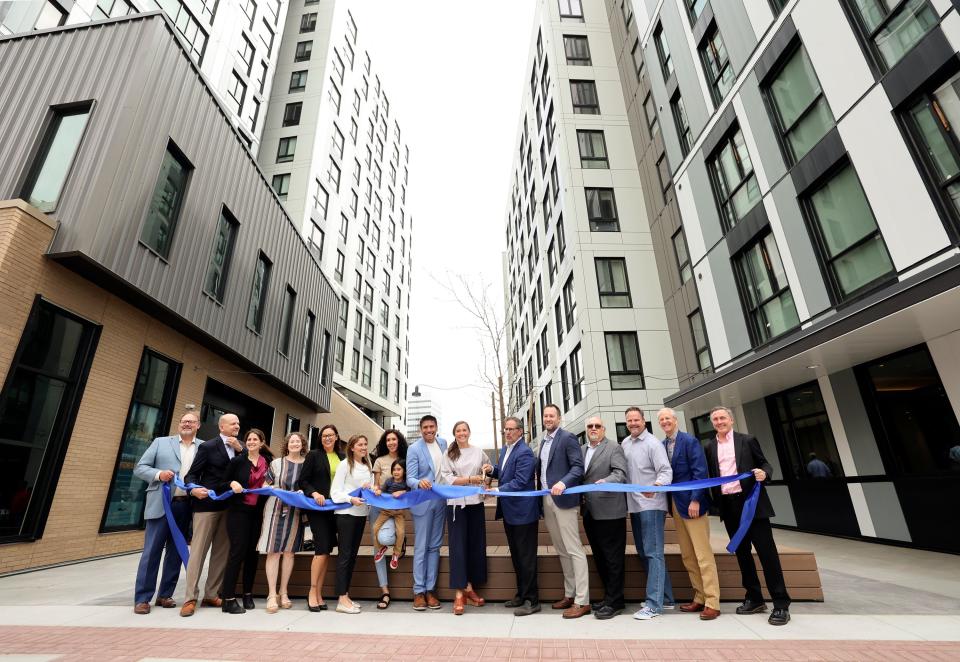 Salt Lake City Mayor Erin Mendenhall, center, cuts the ribbon during a ribbon-cutting ceremony for The Aster, a three-building development that includes low-income housing, commercial and public spaces, in Salt Lake City on Tuesday, May 2, 2023. | Kristin Murphy, Deseret News