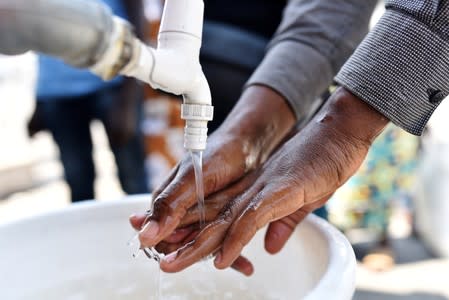 FILE PHOTO: A man washes his hands after Ebola screening upon entering the General Hospital in Goma