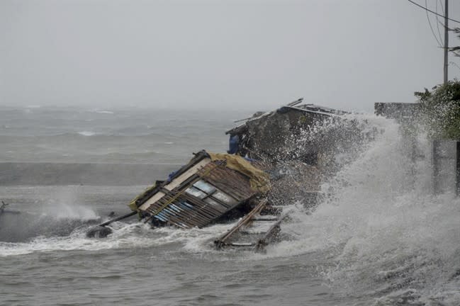 A house is engulfed by the storm surge brought about by powerful typhoon Haiyan that hit Legazpi city, Albay province Friday Nov.8, 2013 about 520 kilometers ( 325 miles) south of Manila, Philippines. Typhoon Haiyan, one of the most powerful typhoons ever recorded slammed into the Philippines on Friday, setting off landslides, knocking out power in one entire province and cutting communications in the country's central region of island provinces. (AP Photo/Nelson Salting)