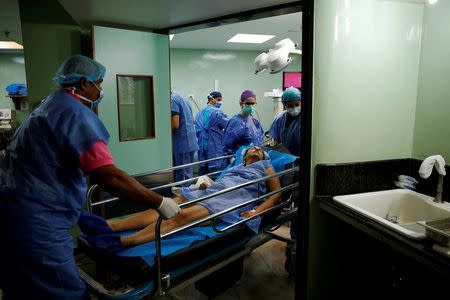 Medical personnel move a woman after her sterilization surgery in the operating room of a hospital in Caracas, Venezuela July 27, 2016. REUTERS/Carlos Garcia Rawlins