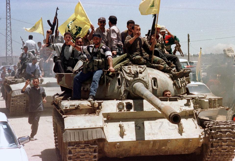 FILE - Waving their flags, Hezbollah guerrillas sit on a top of an Israeli allied South Lebanon Army tank while touring in the streets near the village of Kfar Kila, May 24, 2000. Forty years since it was founded, Lebanon's Hezbollah has transformed from a ragtag organization to the largest and most heavily armed militant group in the Middle East. (AP Photo/Mohamed Zatari, File)