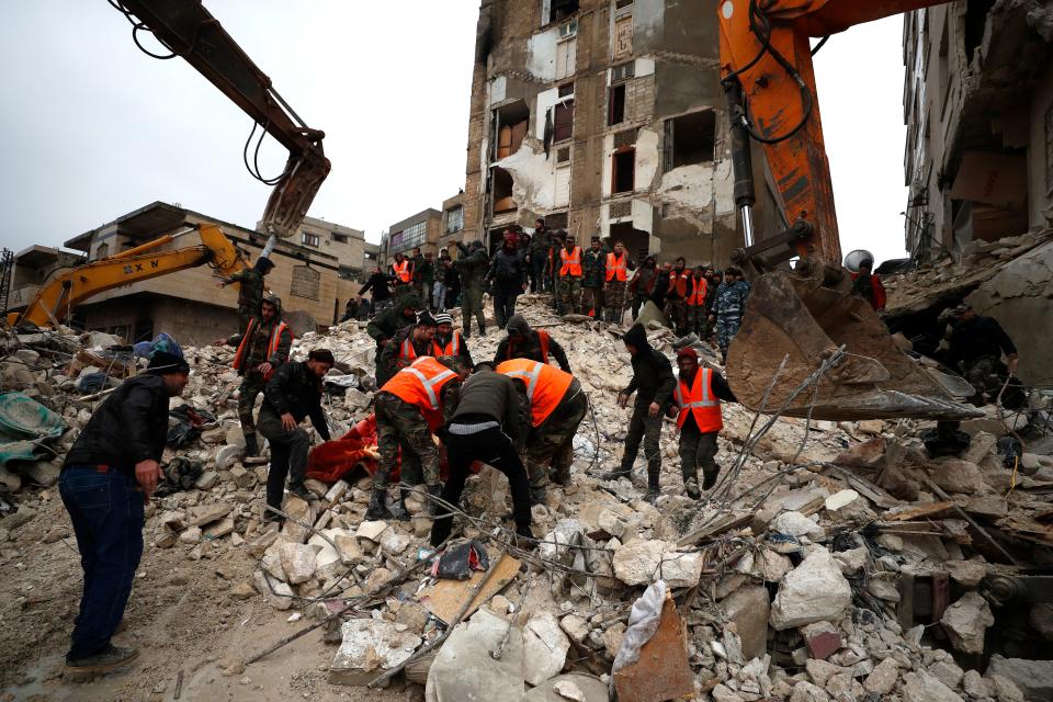 Civil defense workers and security forces search through the wreckage of collapsed buildings in Hama, Syria, Monday, Feb. 6, 2023.