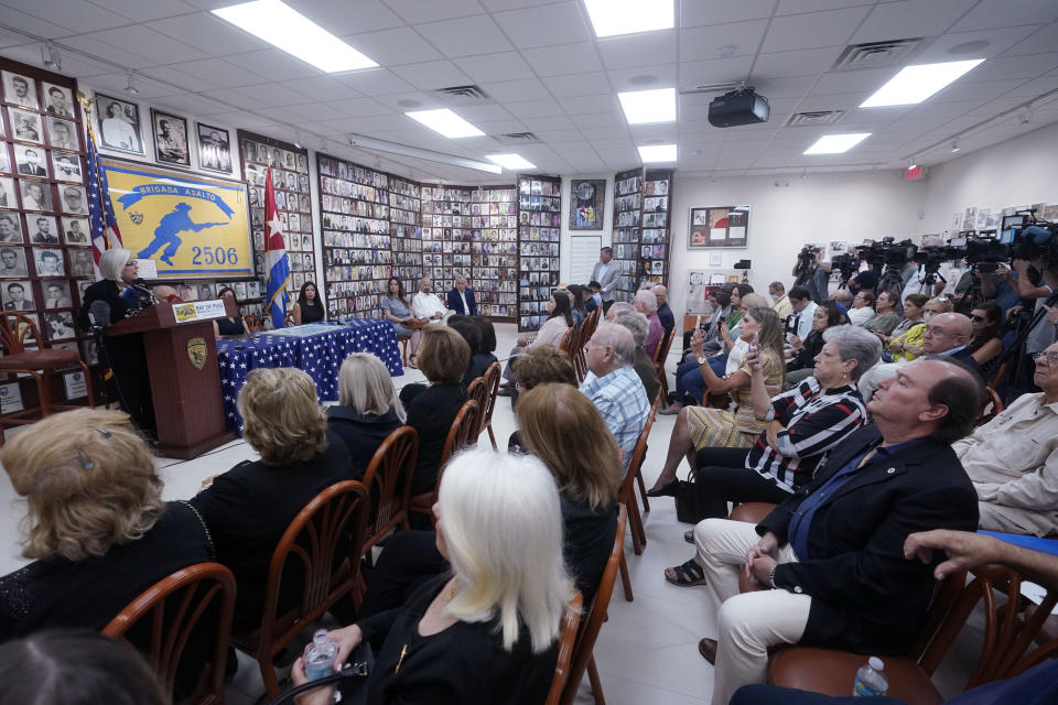 Sylvia Iriondo, left rear, president of Mothers and Women Against Repression, speaks at a news conference along with other Cuban exiles, of their concern of the sale of two local Spanish language radio stations, Wednesday, June 8, 2022, at the Bay of Pigs Museum and Brigade 2506 headquarters in Miami's Little Havana neighborhood. The deal involving Spanish-language radio stations is stirring up opposition in Miami, where Cuban exiles describe it as a clear attempt by Democrats to stifle conservative and anti-Communist voices in the Hispanic community where they've lost ground. (AP Photo/Wilfredo Lee)
