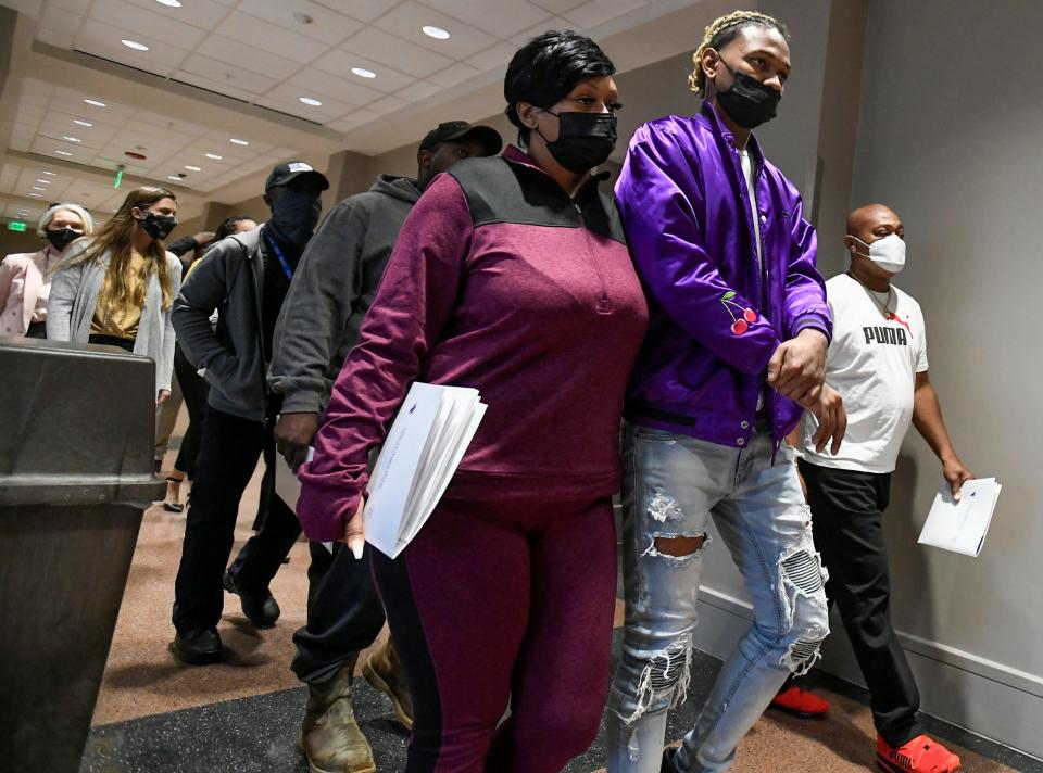 Shooting victim Markarius Watson, front center, and family members of victims arrive for the bail hearing for Tory Johnson, a suspect in the Bama Lanes shooting, at the Montgomery County Courthouse in Montgomery, Ala., on Thursday January 13, 2022. 