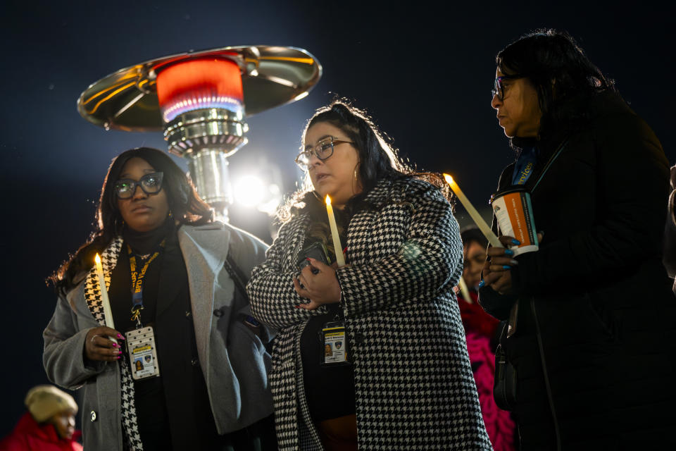 Several city employees hold candles while the names of the homicide victims are being read aloud during a vigil for the homicide victims of 2023 on Wednesday, Jan. 3, 2023 in Baltimore. Mayor Brandon Scott hosted the vigil. (Kaitlin Newman /The Baltimore Banner via AP)