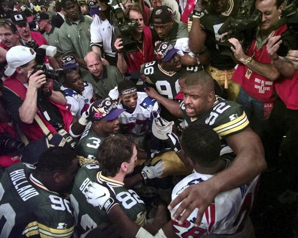 FILE - Green Bay Packers' Reggie White (92) leads a prayer service after the Packers defeated the New England Patriots 35-21 in Super Bowl XXXI Sunday, Jan. 26, 1997 at the Superdome in New Orleans. Hall of Fame defensive lineman Reggie White - a former Eagles, Packers and Panthers player known as the “Minister of Defense” - is credited with starting the postgame prayer circle at midfield in the 1980s. (AP Photo/Elaine Thompson, File)