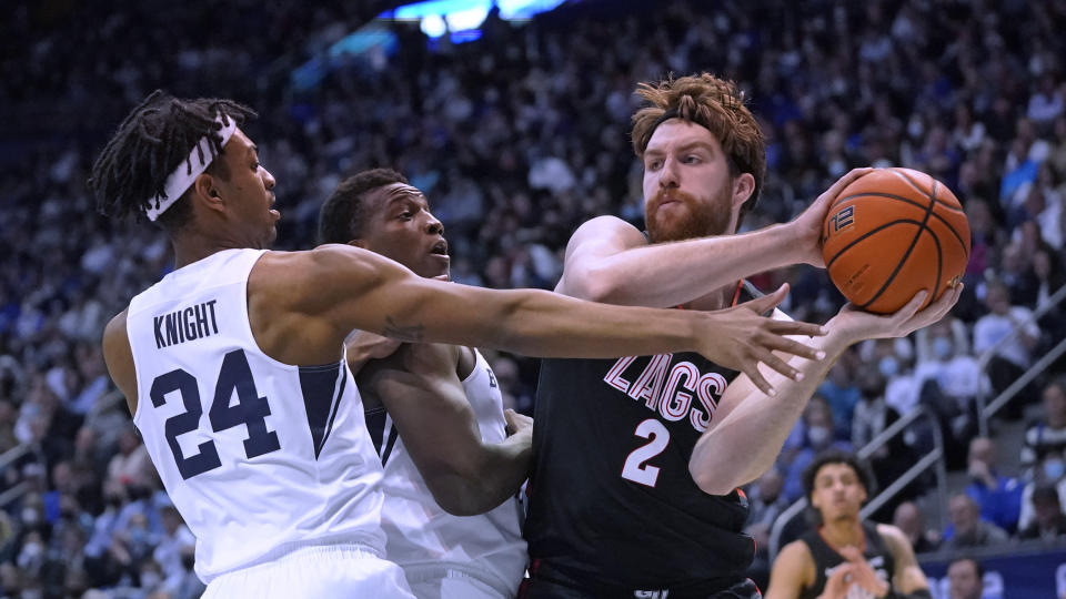 BYU's Seneca Knight (24) and Fousseyni Traore, center, defend against Gonzaga forward Drew Timme (2) during the second half of an NCAA college basketball game Saturday, Feb. 5, 2022, in Provo, Utah. (AP Photo/Rick Bowmer)