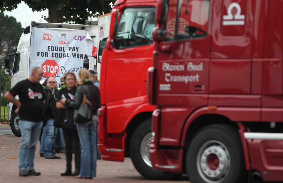 Truckers have a chat as they are parked, during a demonstration in Brussels, Monday Sept. 24, 2012. Truckers seek to disrupt morning traffic heading into the capital to protest competition from eastern Europe, which undercuts prices and lowers labor standards. (AP Photo/Yves Logghe)