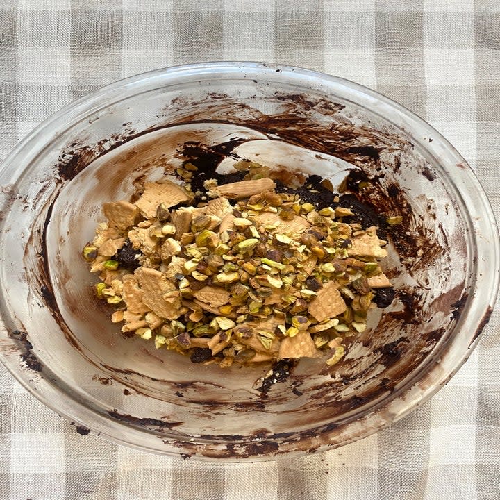 crushed cookies and pistachios added to the bowl with the chocolate salami mixture