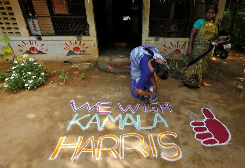 Woman applies finishing touches to a message for U.S. Democratic vice presidential nominee Kamala Harris in Painganadu