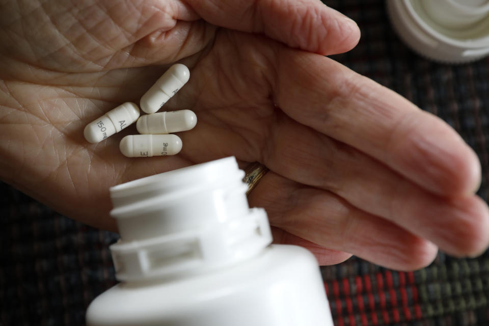 Retired public school teacher Gail Orcutt, of Altoona, Iowa, holds some of the prescription drugs she takes, Friday, Feb. 15, 2019, in Altoona, Iowa. Orcutt pays $2,600 the first month of the year, and then $750 every other month for a lung cancer medication. With health care a top issue for American voters, Congress may actually be moving toward doing something this year to address the high cost of prescription drugs. (AP Photo/Charlie Neibergall)