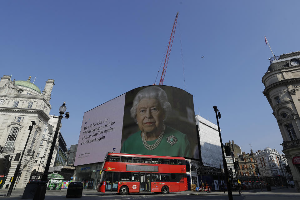 FILE - In this Thursday, April 9, 2020 file photo an image of Britain's Queen Elizabeth II and quotes from her historic television broadcast commenting on the coronavirus pandemic are displayed on a big screen at Piccadilly Circus in London. (AP Photo/Kirsty Wigglesworth, File)