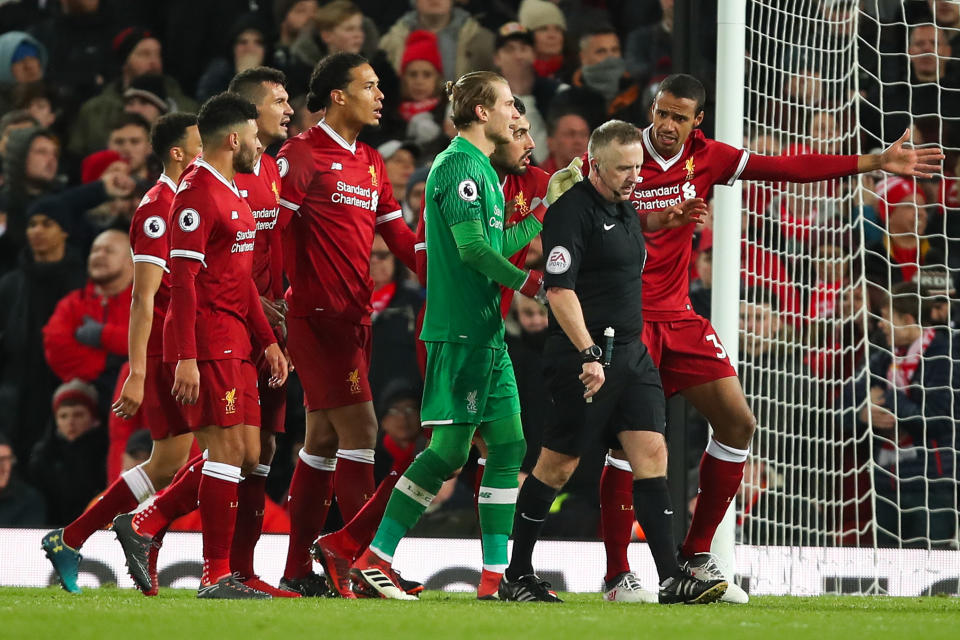 Liverpool players hound referee John Moss after one of two controversial penalty decisions against them. (Getty)