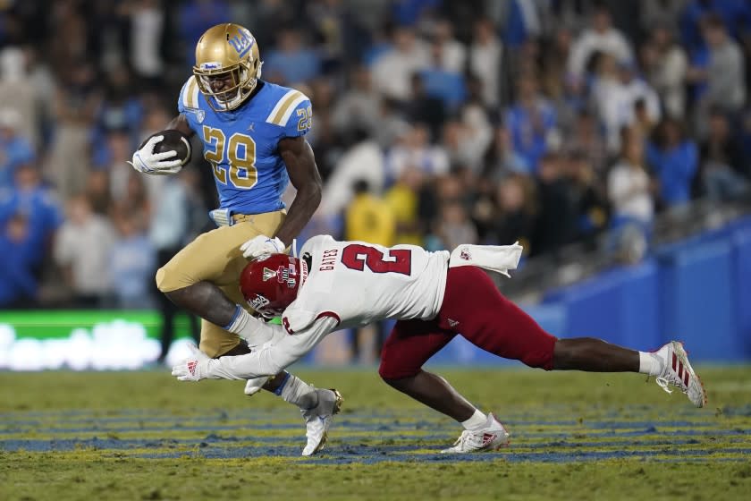 UCLA running back Brittain Brown (28) runs past Fresno State defensive back Elijah Gates (2) during the first half of an NCAA college football game Saturday, Sept. 18, 2021, in Pasadena, Calif. (AP Photo/Marcio Jose Sanchez)