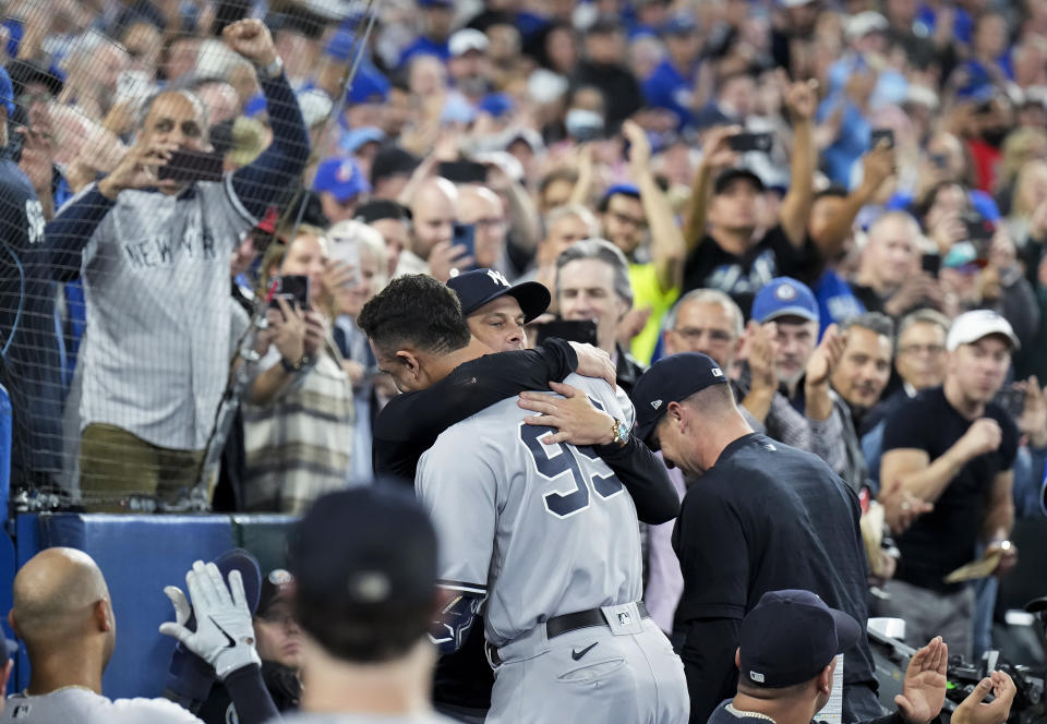 Aaron Judge, de los Yanquis de Nueva York, es felicitado por el manager Aaron Boone, tras conseguir su 61er jonrón de la campaña, el miércoles 28 de septiembre de 2022, ante los Azulejos de Toronto (Nathan Denette/The Canadian Press via AP)