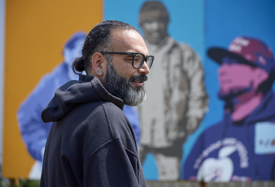 Edgar Franks stops and talks about the farm worker union organizing in front of a mural at the Coopertiva Tierra y Libertad farm Friday, July 7, 2023, in Everson, Wash. Farms and workers must adapt to changing climate conditions. (AP Photo/John Froschauer)