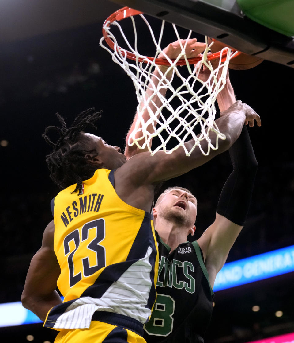 Boston Celtics center Kristaps Porzingis (8) is fouled by Indiana Pacers forward Aaron Nesmith (23) on a dunk attempt during the second half of an NBA basketball game Wednesday, Nov. 1, 2023, in Boston. (AP Photo/Charles Krupa)