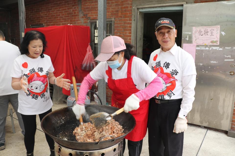 《圖說》大廚黃錦美負責收尾和火候控制，左為泰山區志工協會理事長王月惠，右為泰山區義學社區理事長黃金明。〈社會局提供〉