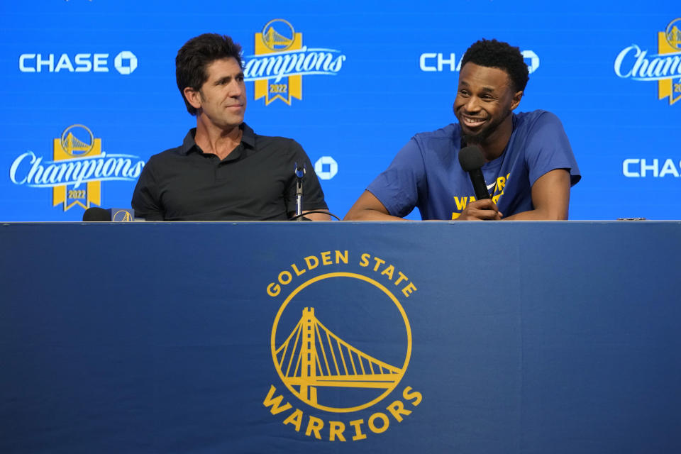 Golden State Warriors forward Andrew Wiggins, right, and general manager Bob Myers take part in a news conference before an NBA basketball game between the Warriors and the Oklahoma City Thunder in San Francisco, Tuesday, April 4, 2023. (AP Photo/Jeff Chiu)