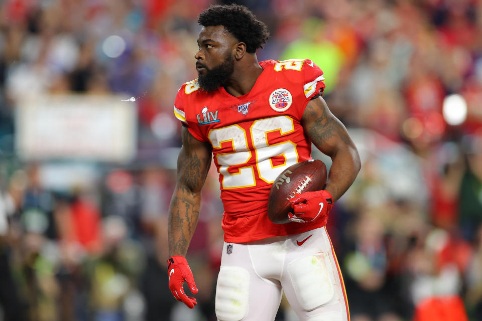 Damien Williams in a red Chiefs jersey holding a football during the Super Bowl. 