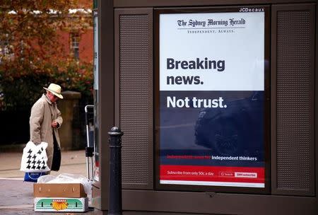 A pedestrian walks past an advertisement for the Fairfax newspaper the Sydney Morning Herald near the location of a protest by Fairfax staff regarding further editorial staff cuts in central Sydney, Australia, May 4, 2017. REUTERS/David Gray