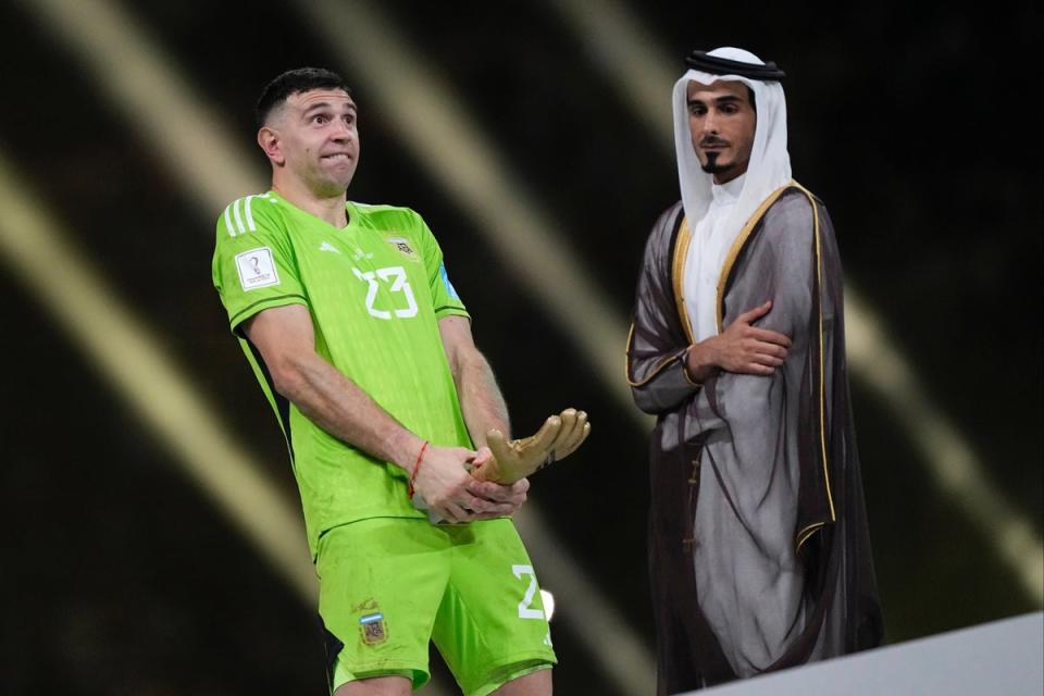 Emiliano Martinez gestures with the FIFA Golden Glove award during the trophy ceremony at the end of the Qatar 2022 World Cup final (AP)