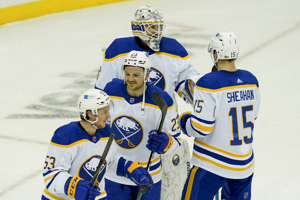 Buffalo Sabres center Sam Reinhart (23) celebrates with left wing Jeff Skinner (53), goaltender Linus Ullmark (35), and center Riley Sheahan (15) after closing the third period of an NHL hockey game against the New Jersey Devils, Saturday, Feb. 20, 2021, in Newark, N.J. (AP Photo/John Minchillo)
