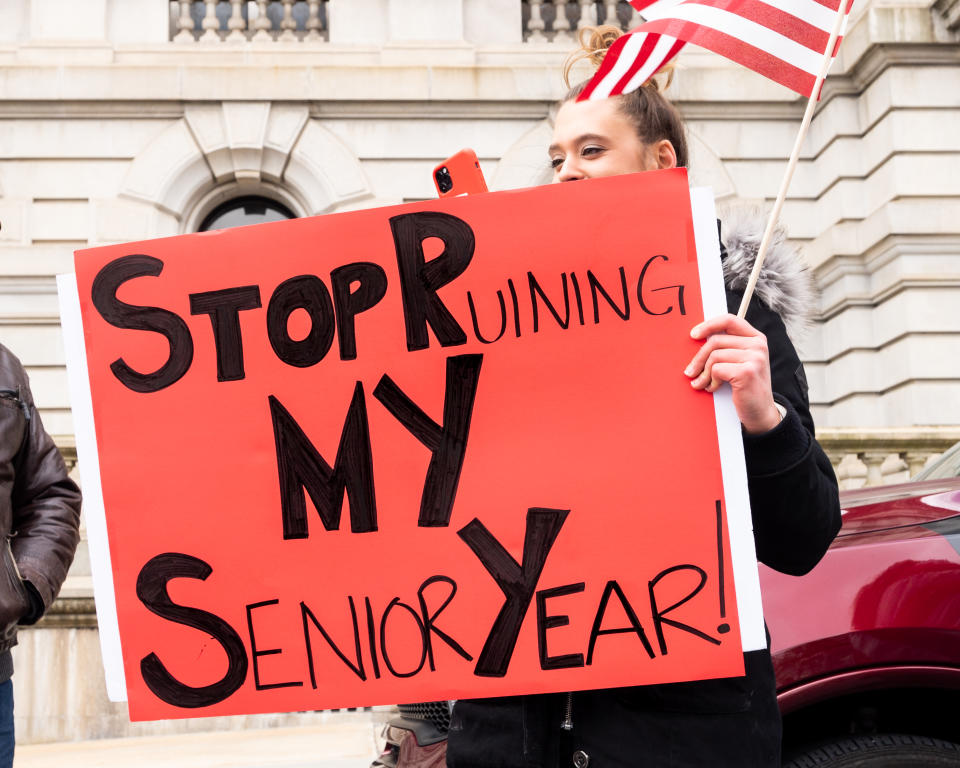 A protester holds a placard that says "Stop ruining my senior year" during the demonstration. People gather outside the New York State Capitol advocating that New York State's regulations shutting down parts of the economy because of the coronavirus should be repealed. (Reuters)