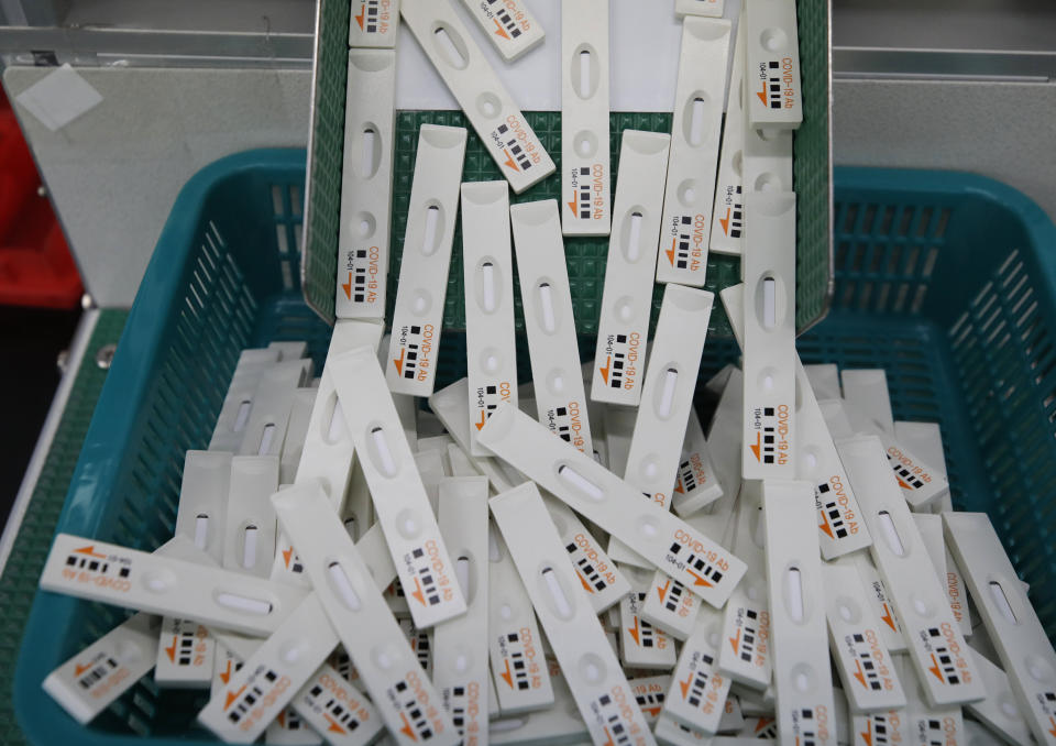 FILE - In this April 17, 2020, file photo, antibody test cartridges of the ichroma COVID-19 Ab testing kit used in diagnosing the coronavirus move along on a production line of the Boditech Med Inc. in Chuncheon, South Korea. Experts say one of the reasons South Korea has managed to avoid lockdowns or business bans was because of its aggressive testing and contact tracing program that draws from its experience of fighting a different coronavirus. (AP Photo/Lee Jin-man, File)