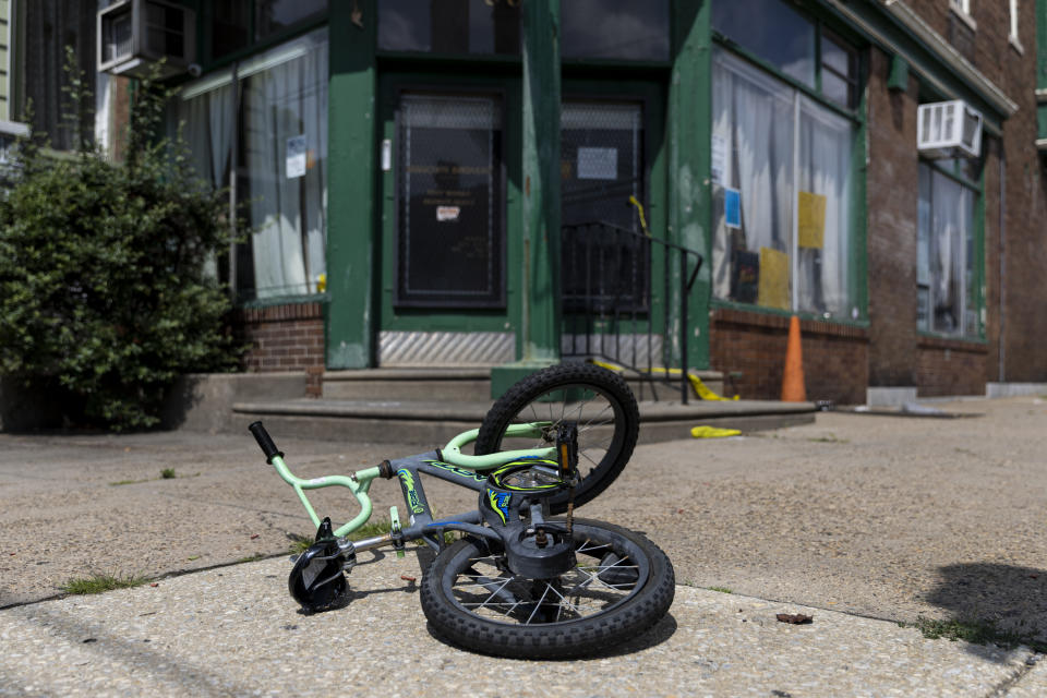 FILE - A child's bike lies on the sidewalk at the scene of a shooting in Philadelphia, on Tuesday, July 4, 2023. A 40-year-old killed one man in a house before fatally shooting four others on the streets of a Philadelphia neighborhood, then surrendering along with a rifle, a pistol, extra magazines, a police scanner and a bulletproof vest, police said. (Tyger Williams/The Philadelphia Inquirer via AP, File)