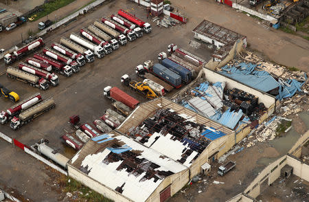 Tankers are seen outside a damaged building in Beira, Mozambique, in the aftermath of Cyclone Idai, March 23, 2019. REUTERS/Mike Hutchings