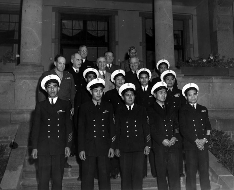 In this Aug. 1, 1945 photo, provided by the President Truman Library, President Harry S. Truman, in the third row, second from right, stands with members of his party and unidentified Filipino stewards during the Potsdam conference in Germany. Asian Americans, veterans and civilians in the U.S. and the Philippines are campaigning to name a Navy warship for a Filipino sailor who bravely rescued two crew members when their ship caught fire more than century ago, earning him a prestigious and rare Medal of Honor. (President Truman Library via AP)