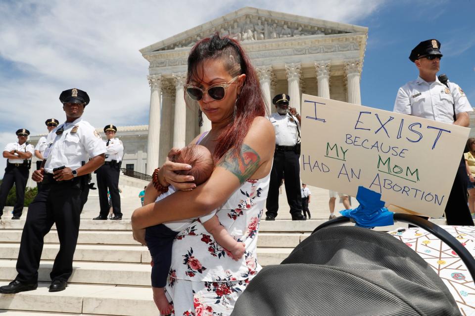 Kristin Mink of Silver Spring, Md., holds her three-week-old daughter during a protest against state abortion bans outside the Supreme Court on May 21.