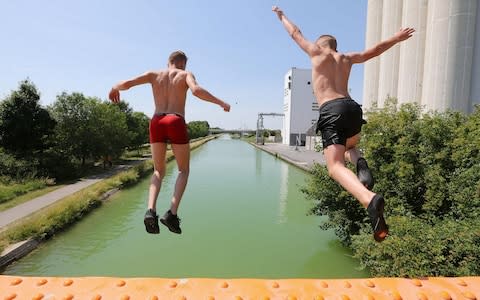 Boys jump into the canal near Reims, northeastern France, as temperatures soar on June 25, 2019.  - Credit: &nbsp;FRANCOIS NASCIMBENI/AFP